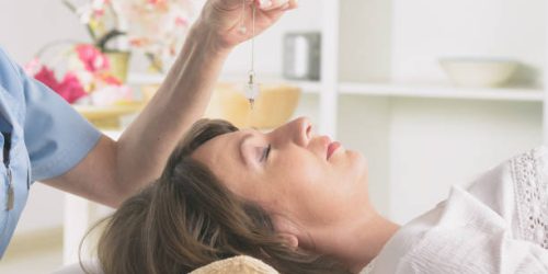 Alternative medicine therapist using pendulum to make a diagnosis Alternative medicine therapist using pendulum to make a diagnosis
