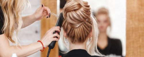 istockphoto-1147811403-612×612 business woman lady boss in beauty salon making hairdress and looking to the mirror