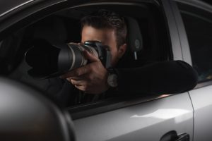 paparazzi-doing-surveillance-by-camera-with-lens-from-his-car